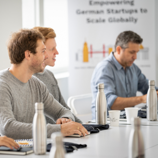 Ein Tisch mit mehreren silbernen Termoflaschen drauf. Mit der Aufschrift 