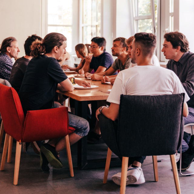 Eine Gruppe von Menschen an einem Tisch, am essen.